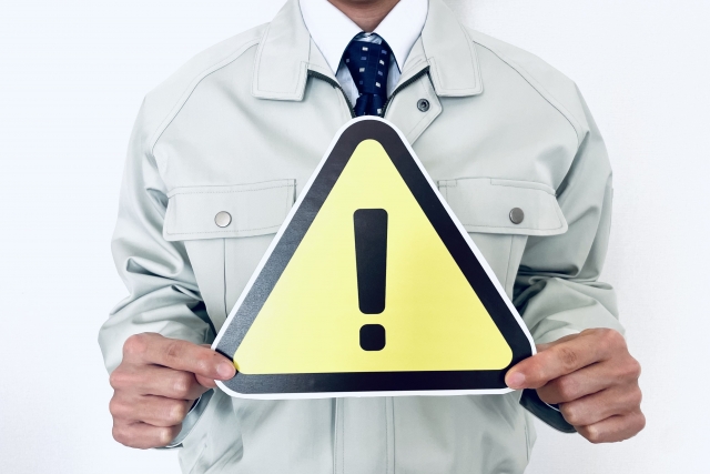 注意マークを持った作業員